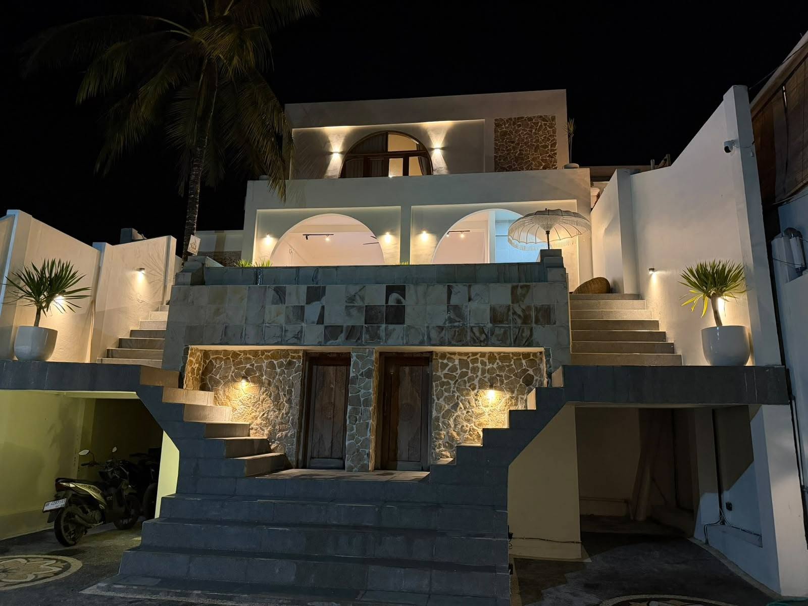 Illuminated multi-level villa exterior and terrace at night in Central Kuta