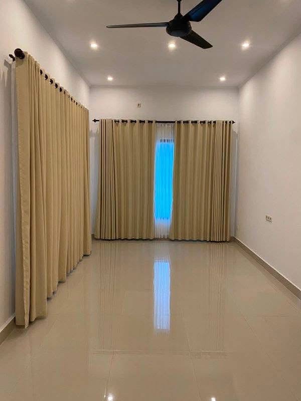 Bright interior room with ceiling fan and curtains in Mengalung house