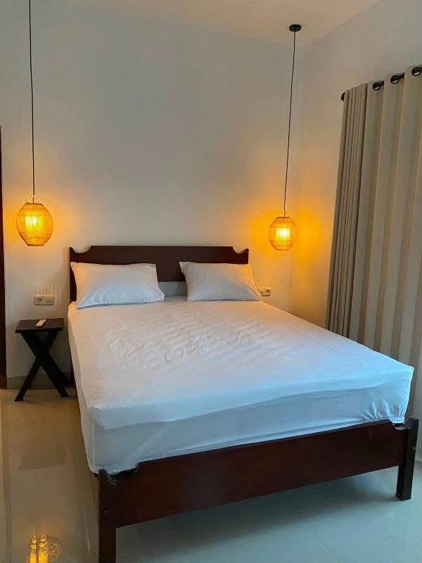 Bedroom with double bed and pendant lights in Mengalung house