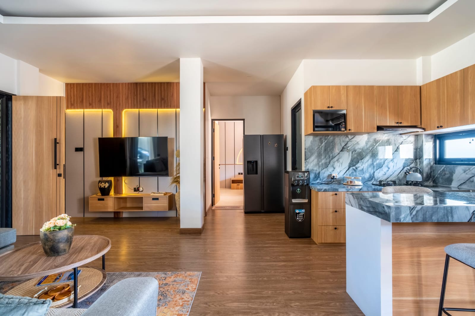 Open-plan lounge with television and kitchen