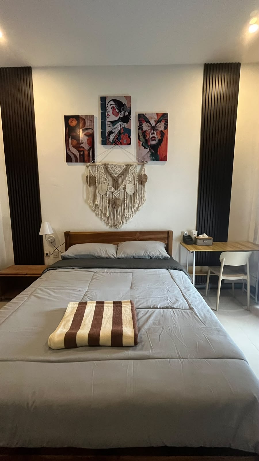 Front view of furnished bedroom with desk and wall art in Central Kuta