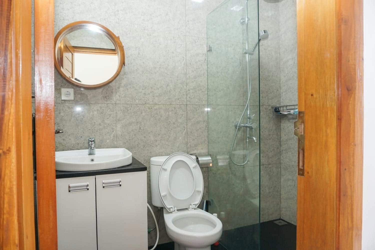 Modern bathroom with glass shower, toilet and vanity