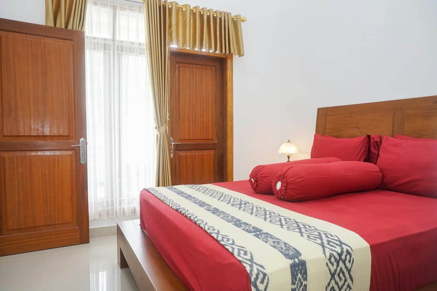 Bedroom with red linen and natural window light