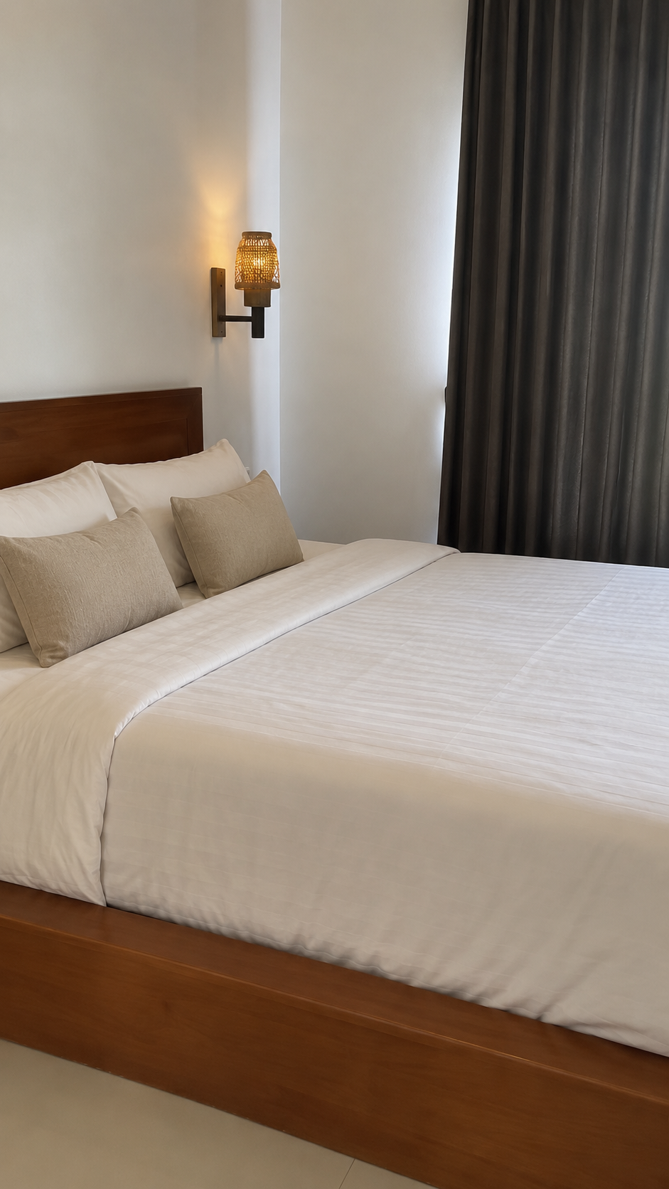 Second view of a bedroom with curtains and wall lamp