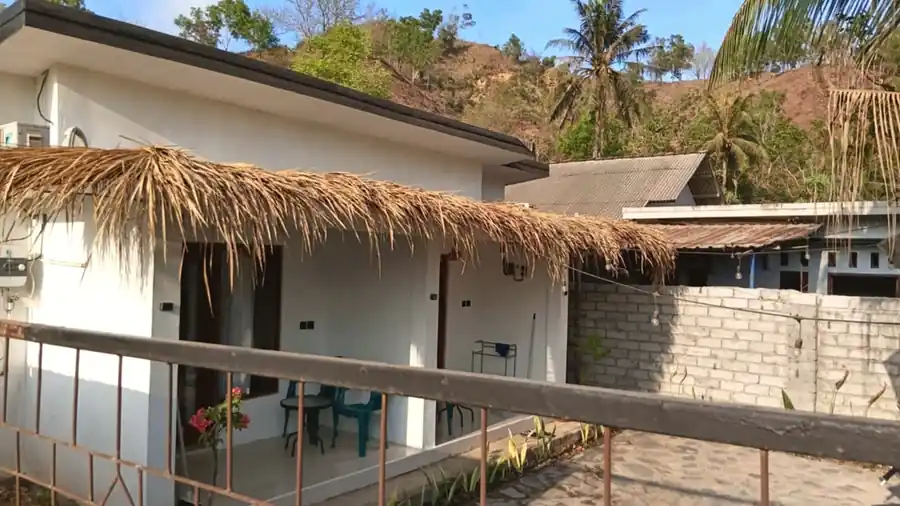 Daytime view of white accommodation and covered thatched terrace